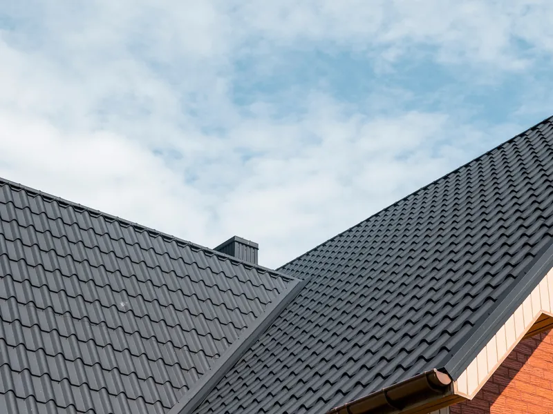 New dark tiled roof on a brick house