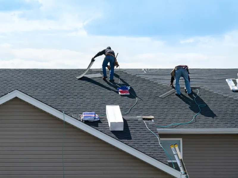 Team of roofers working across a pitched roof